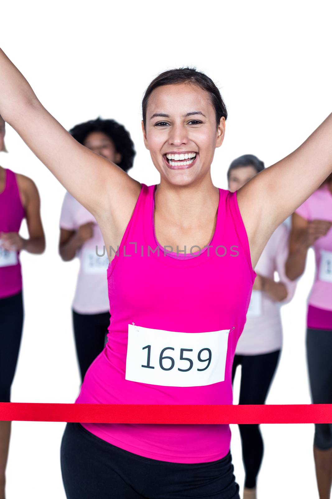 Portrait of cheerful winner athlete crossing finish line with arms raised against white background