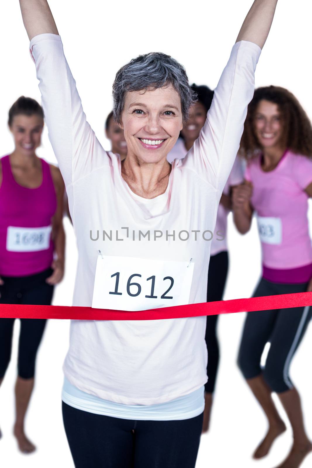 Portrait of happy winner athlete crossing finish line with arms raised against white background