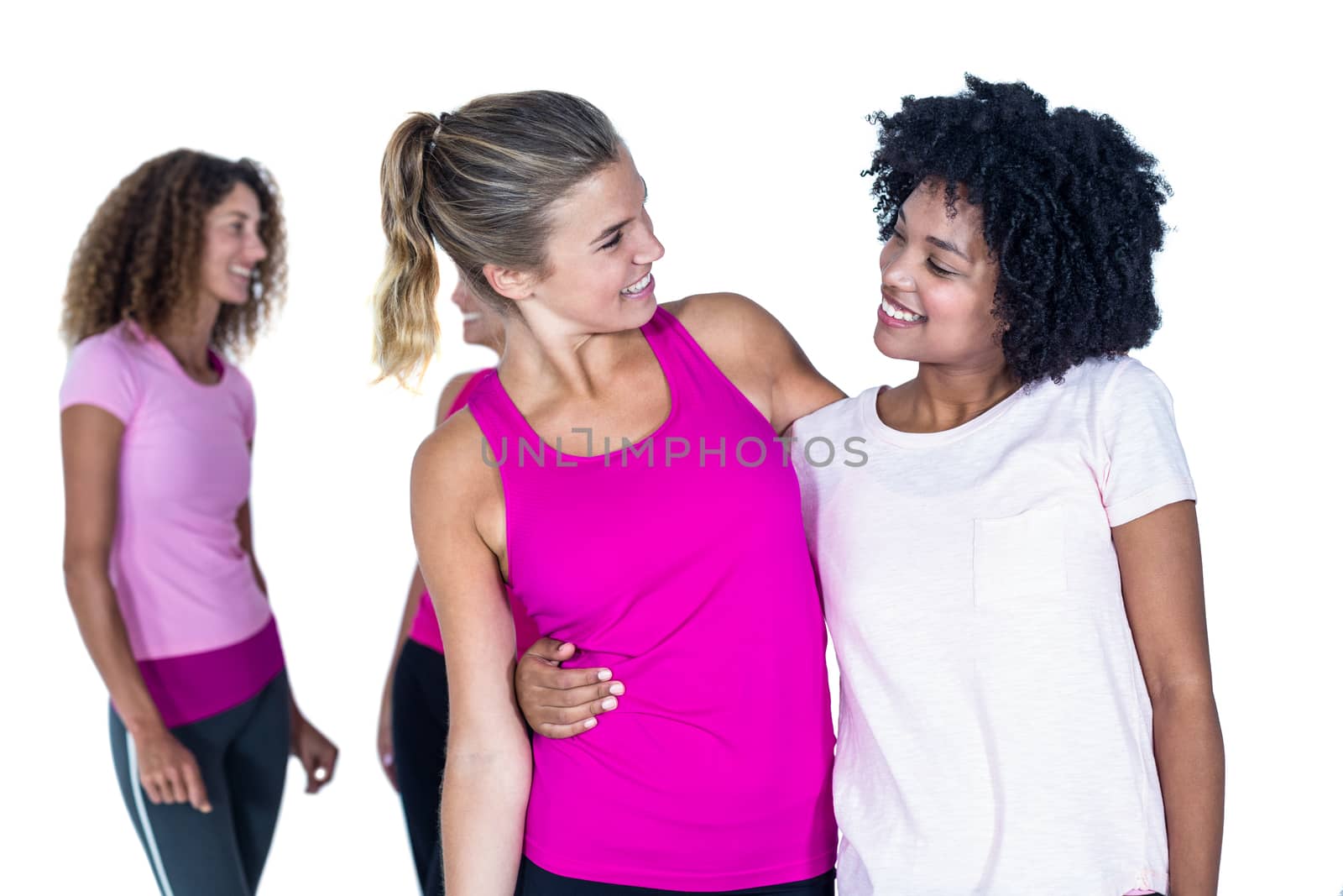 Cheerful women with arms around while standing against white background