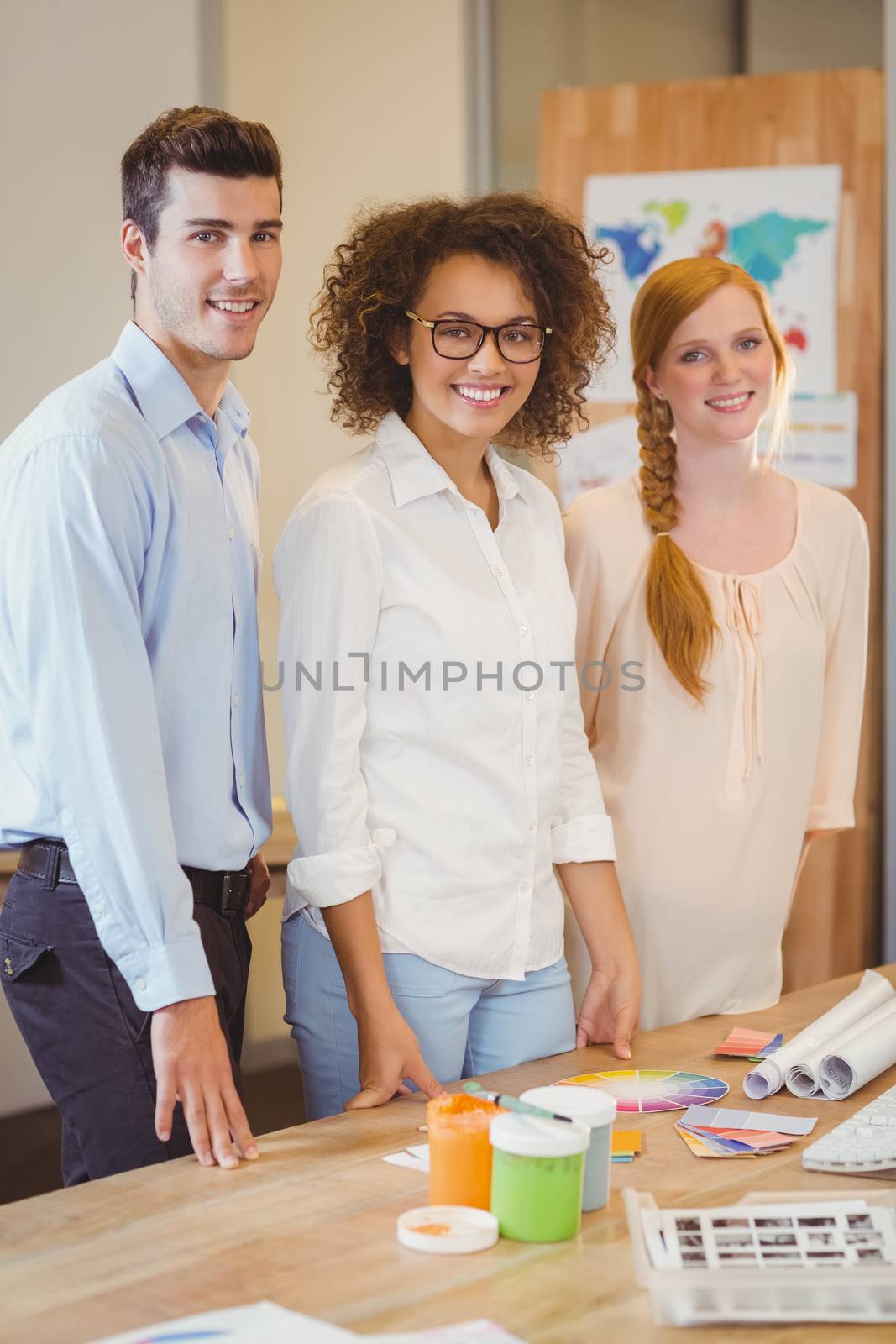 Confident business people standing by desk by Wavebreakmedia