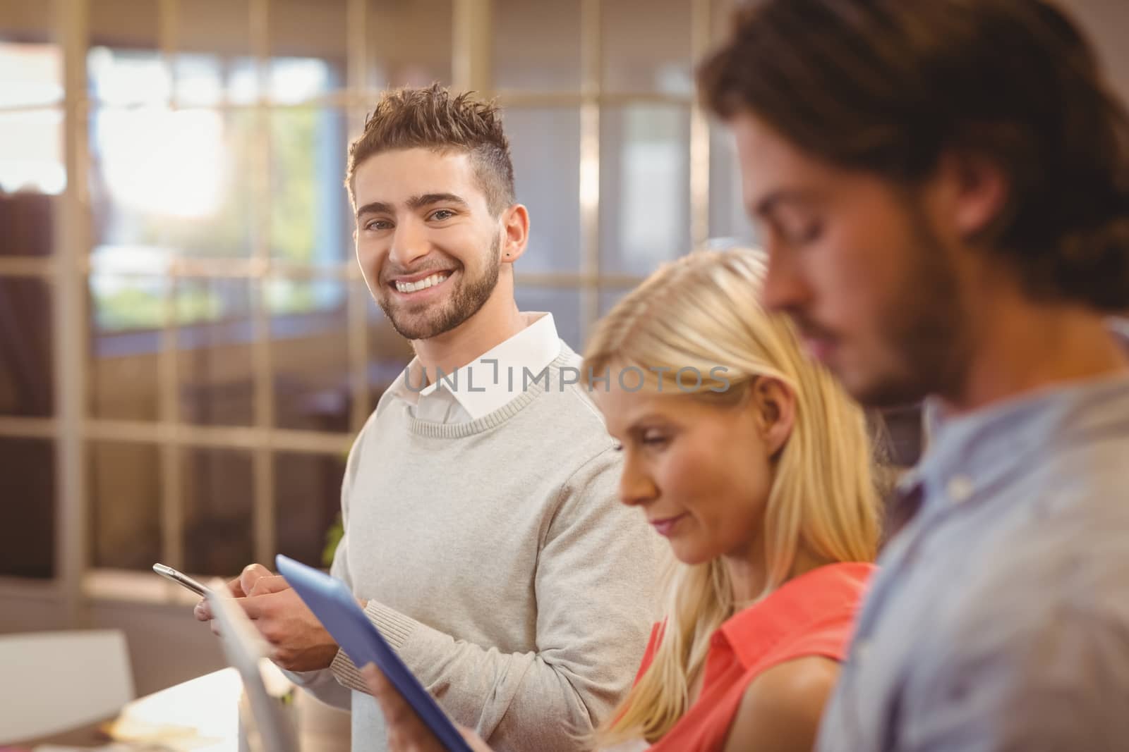 Happy businessman with colleagues working in office by Wavebreakmedia