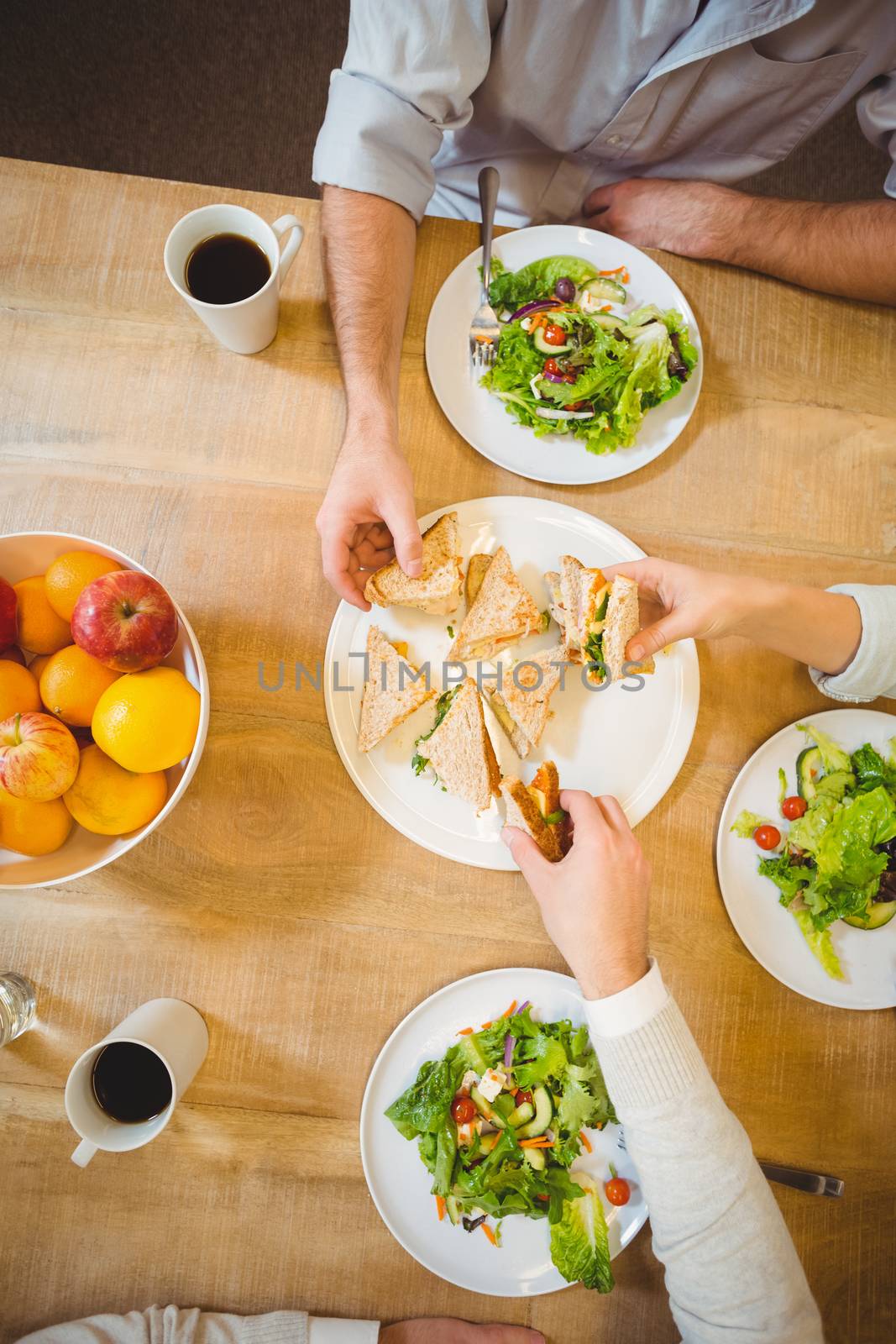 Cropped image of business people having brunch in canteen at creative office