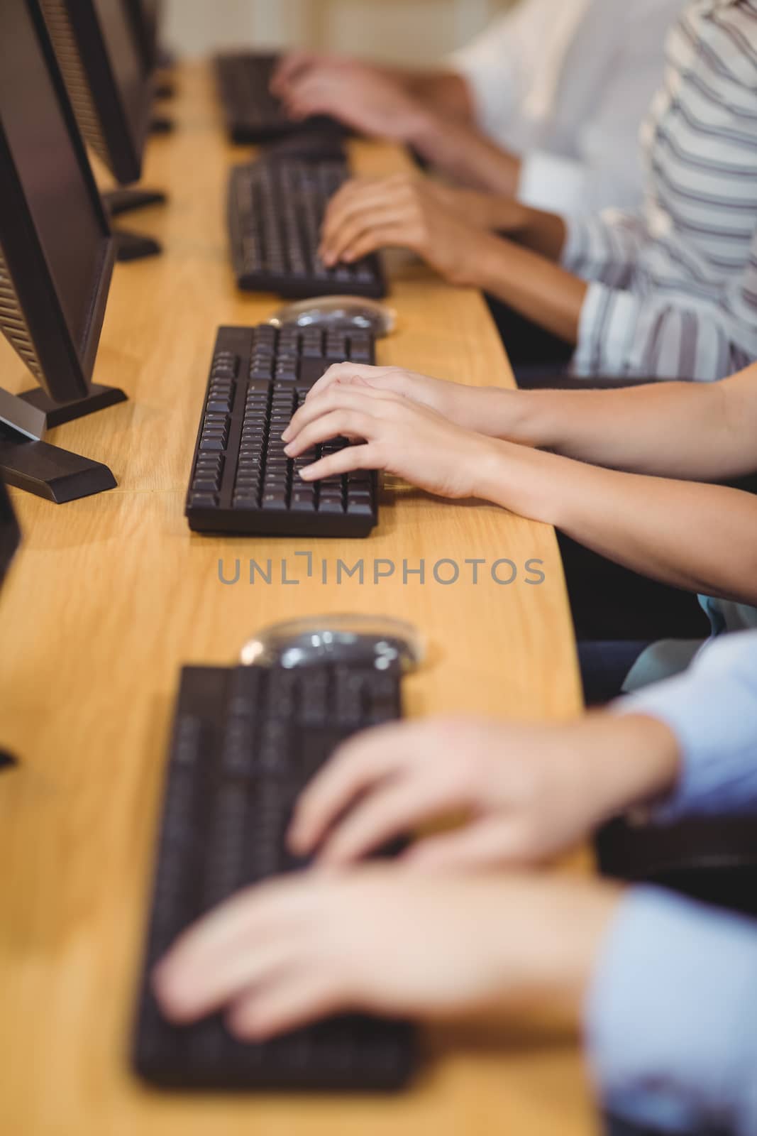 Cropped hands of executives woriking on keyboard in creative office