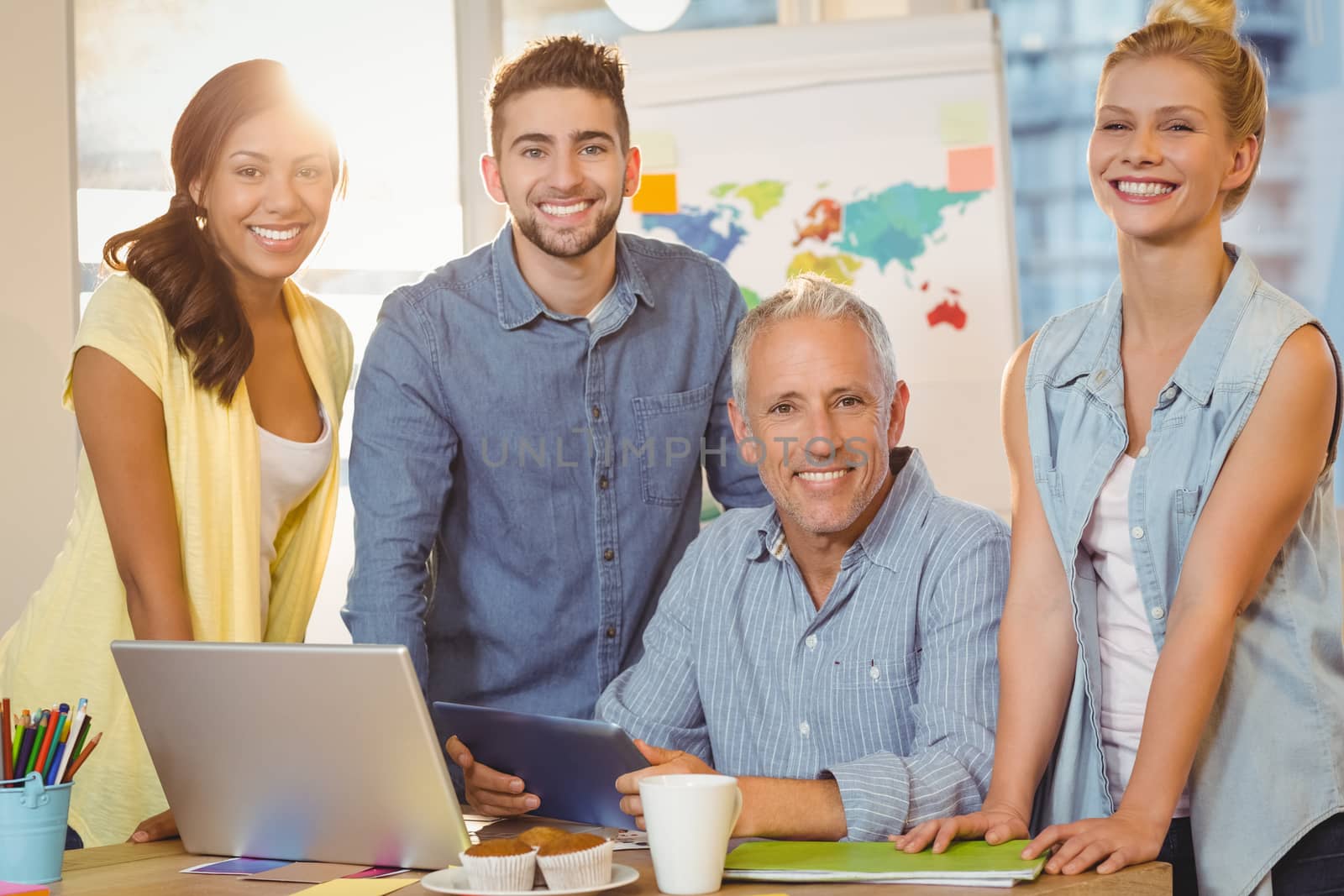 Portrait of happy business people using technologies in meeting room at creative office