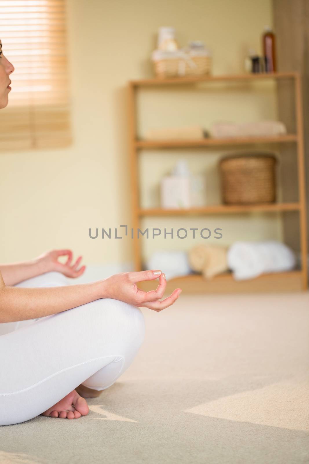 Cropped woman in yoga pose while sitting on floor