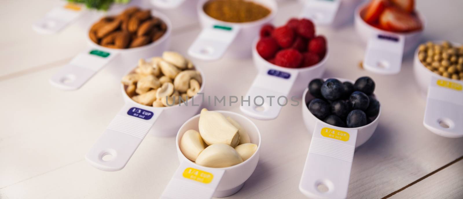 Portion cups of healthy ingredients on wooden table