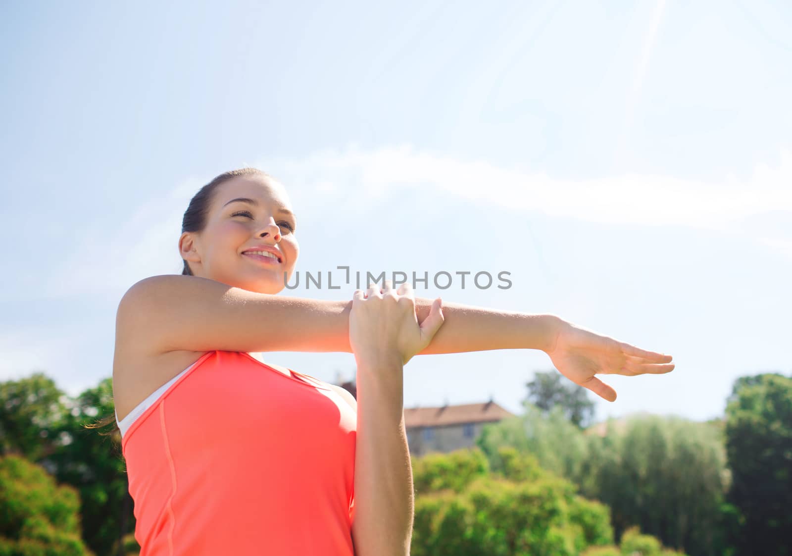 smiling woman stretching outdoors by dolgachov