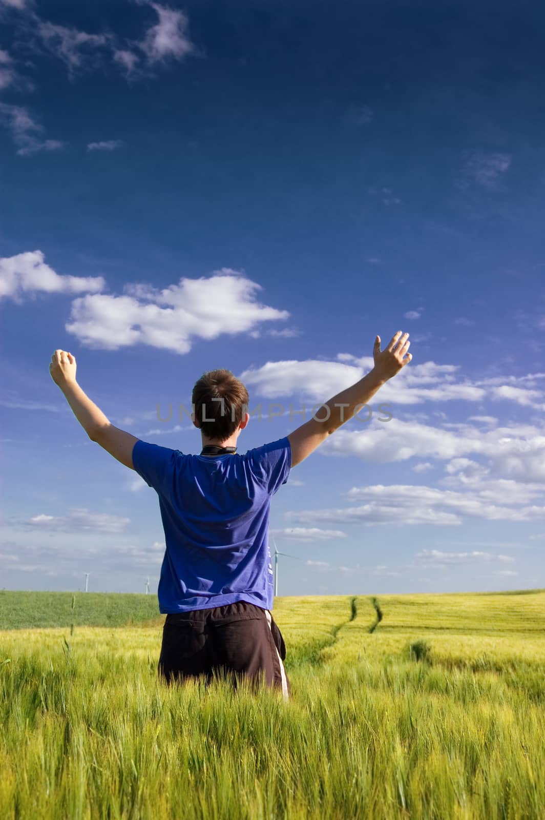 Man standing on the green field at summer and feel the freedom.