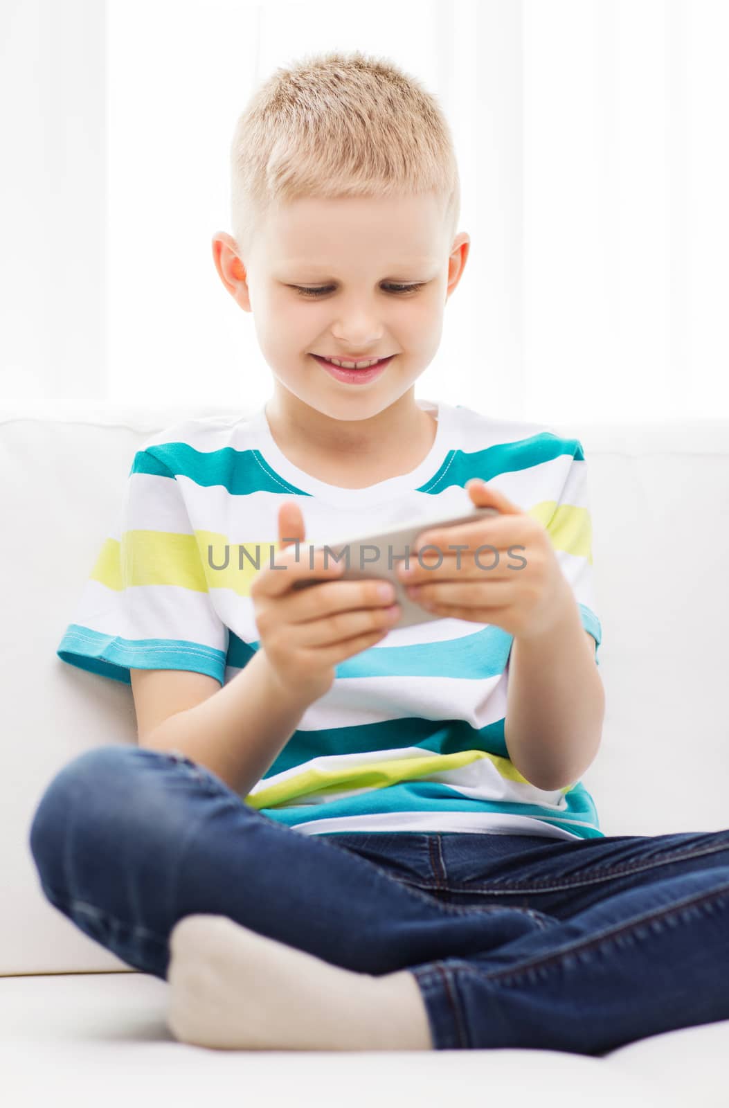 smiling little boy with smartphone by dolgachov