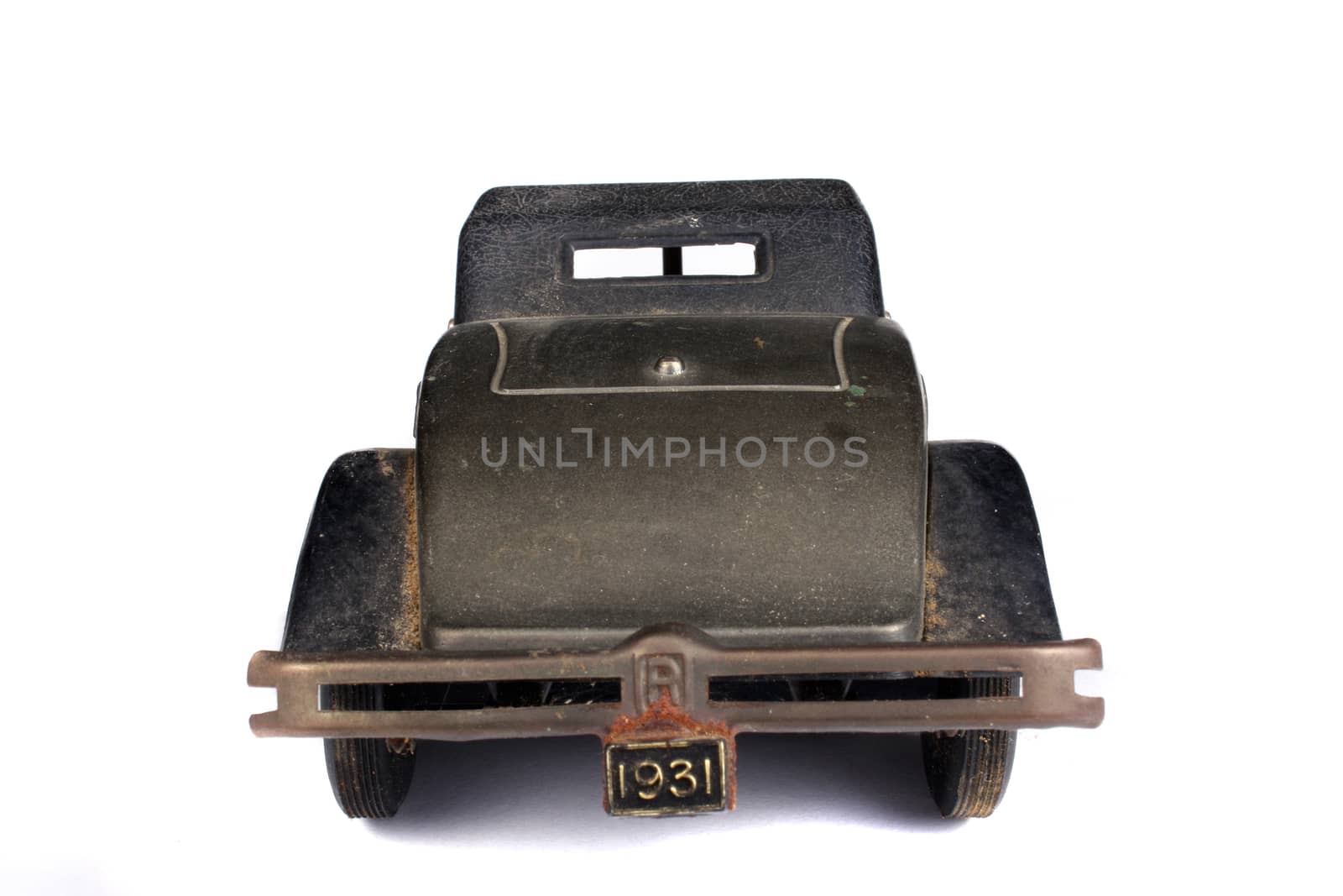 A rear view of a antique vintage car, on white studio background.