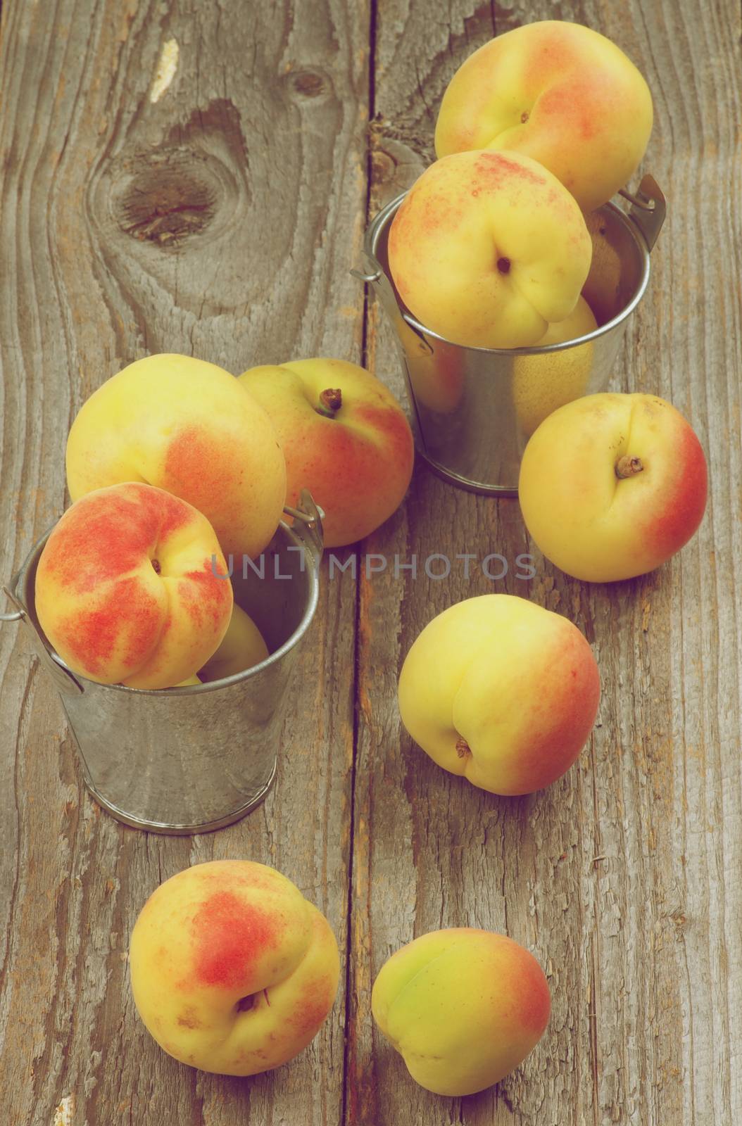 Fresh Ripe Apricots in Tin Buckets closeup on Rustic Wooden background. Retro Styled