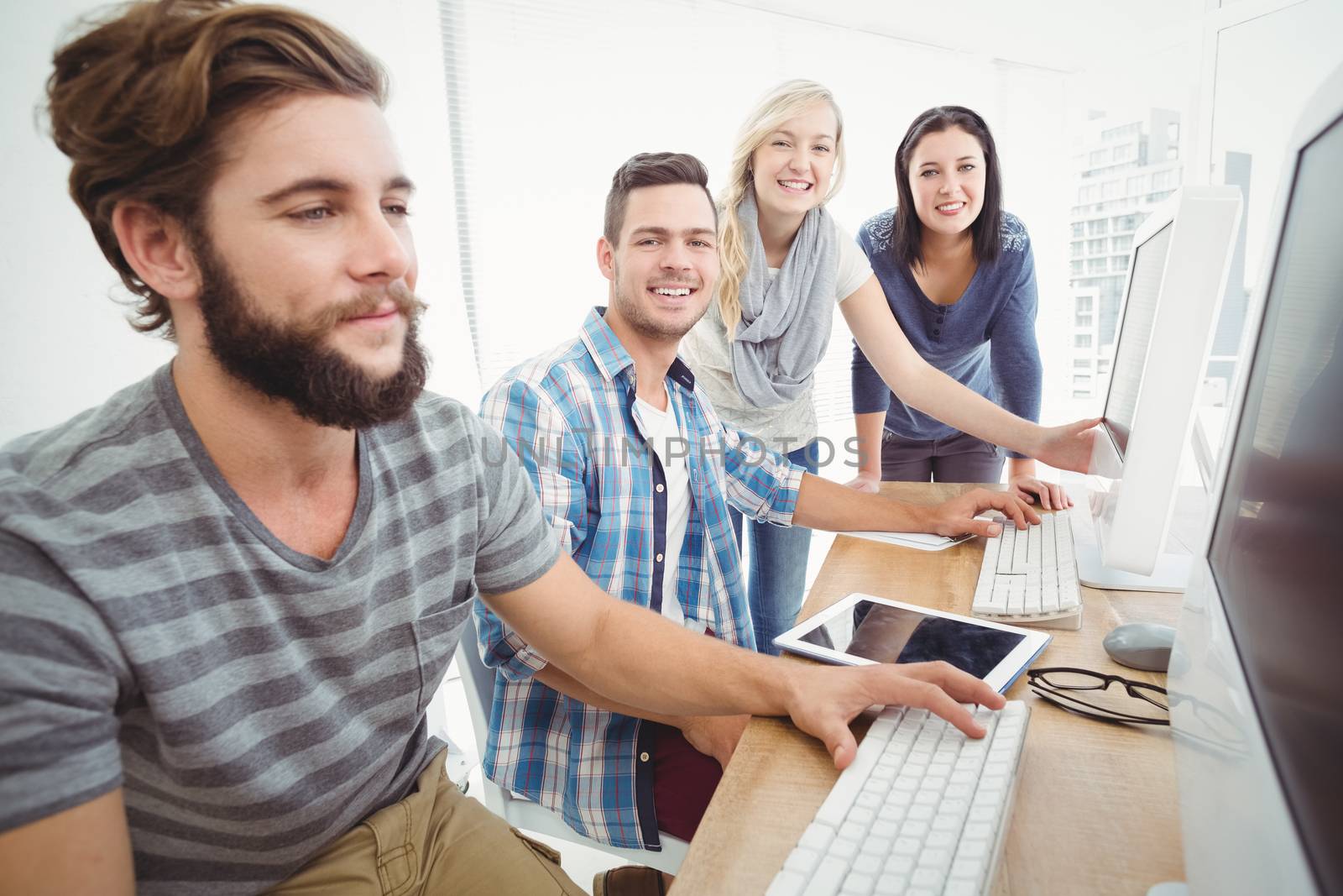 Cheerful business team at computer desk in office