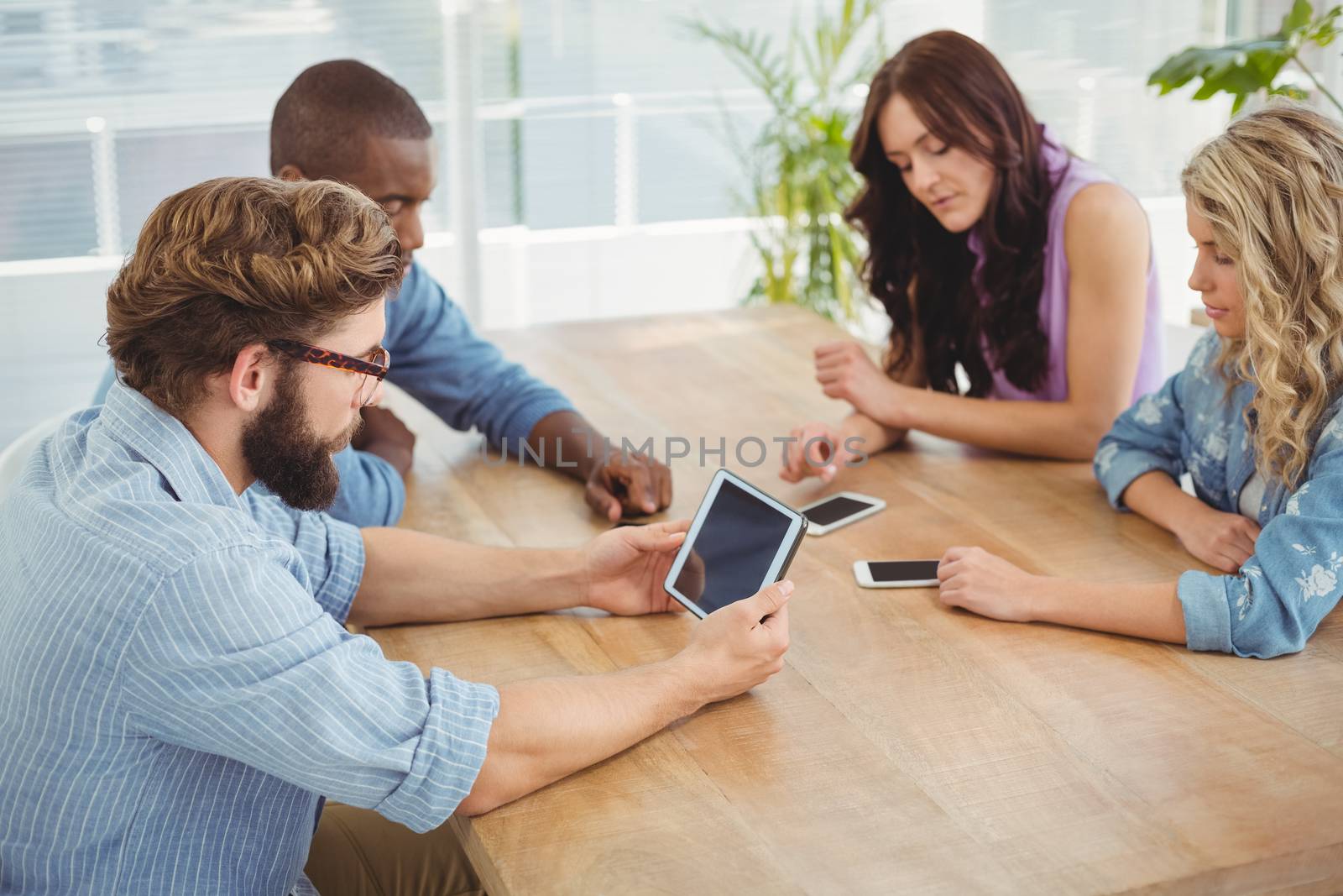 Business professionals using technology at desk in office