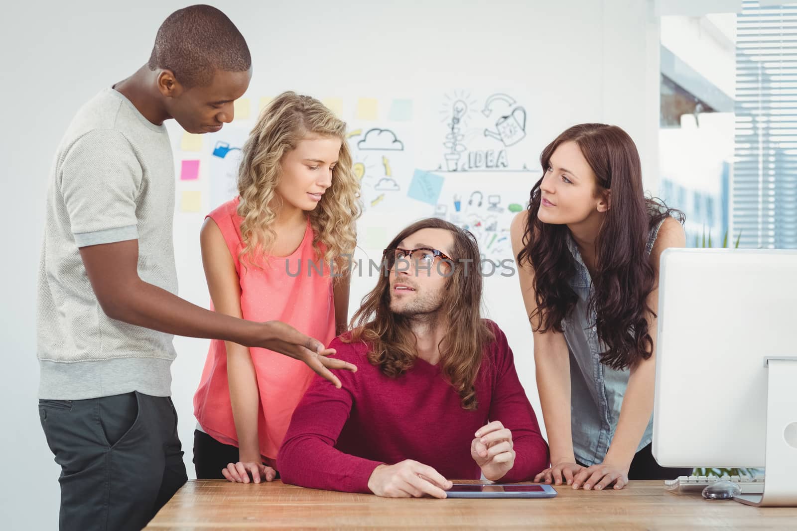 Man gesturing while discussing at desk  by Wavebreakmedia