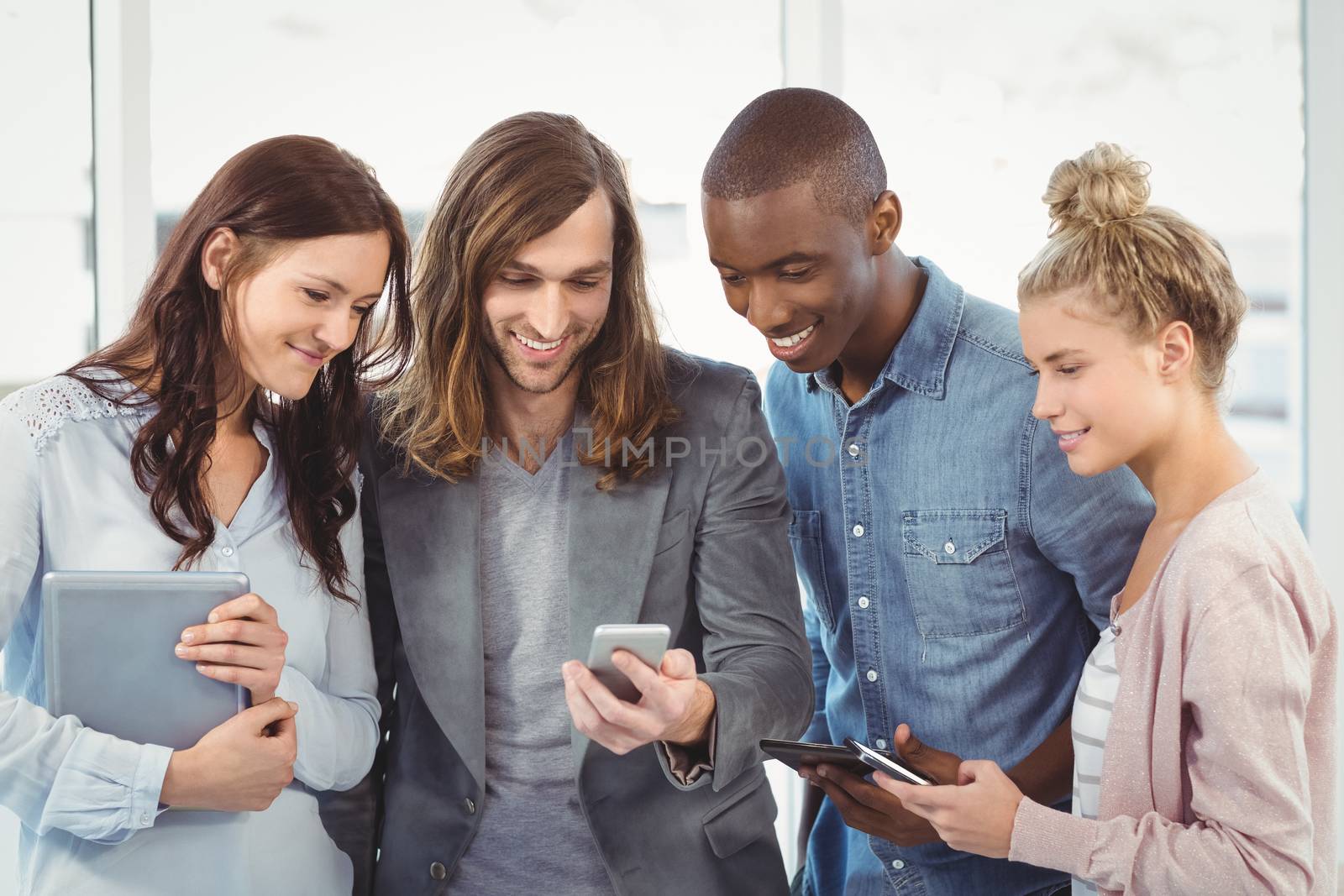 Smiling business team using technology  by Wavebreakmedia