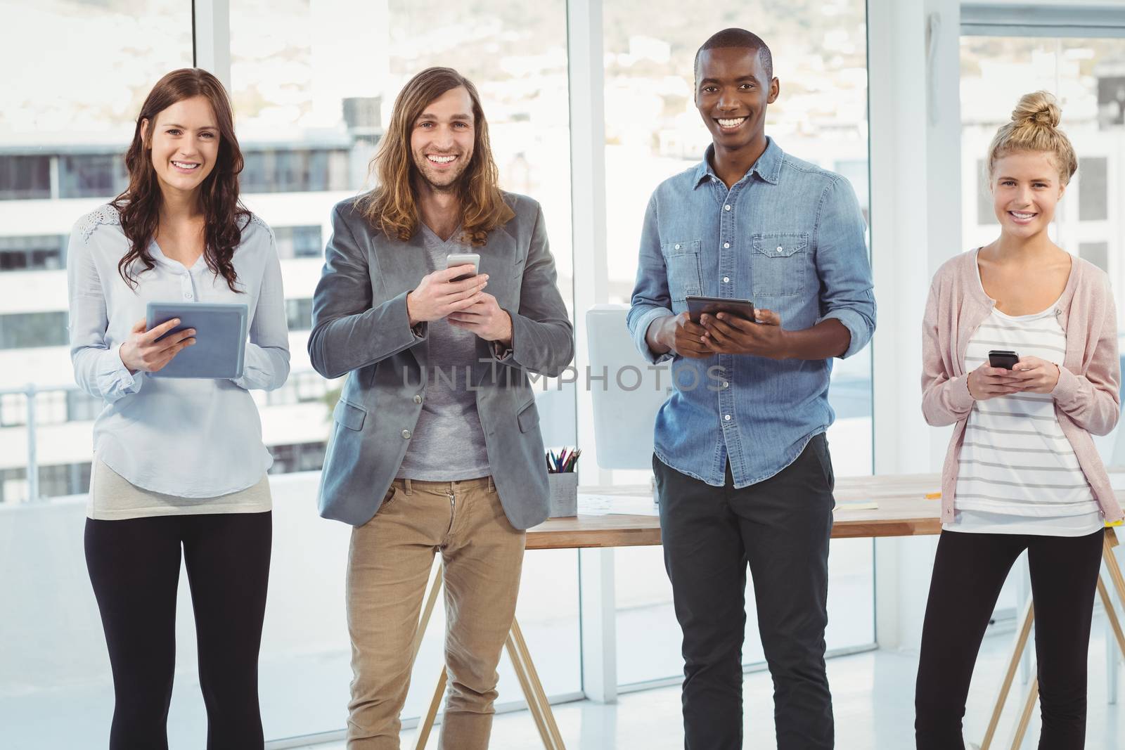 Portrait of cheerful business team using technology  by Wavebreakmedia