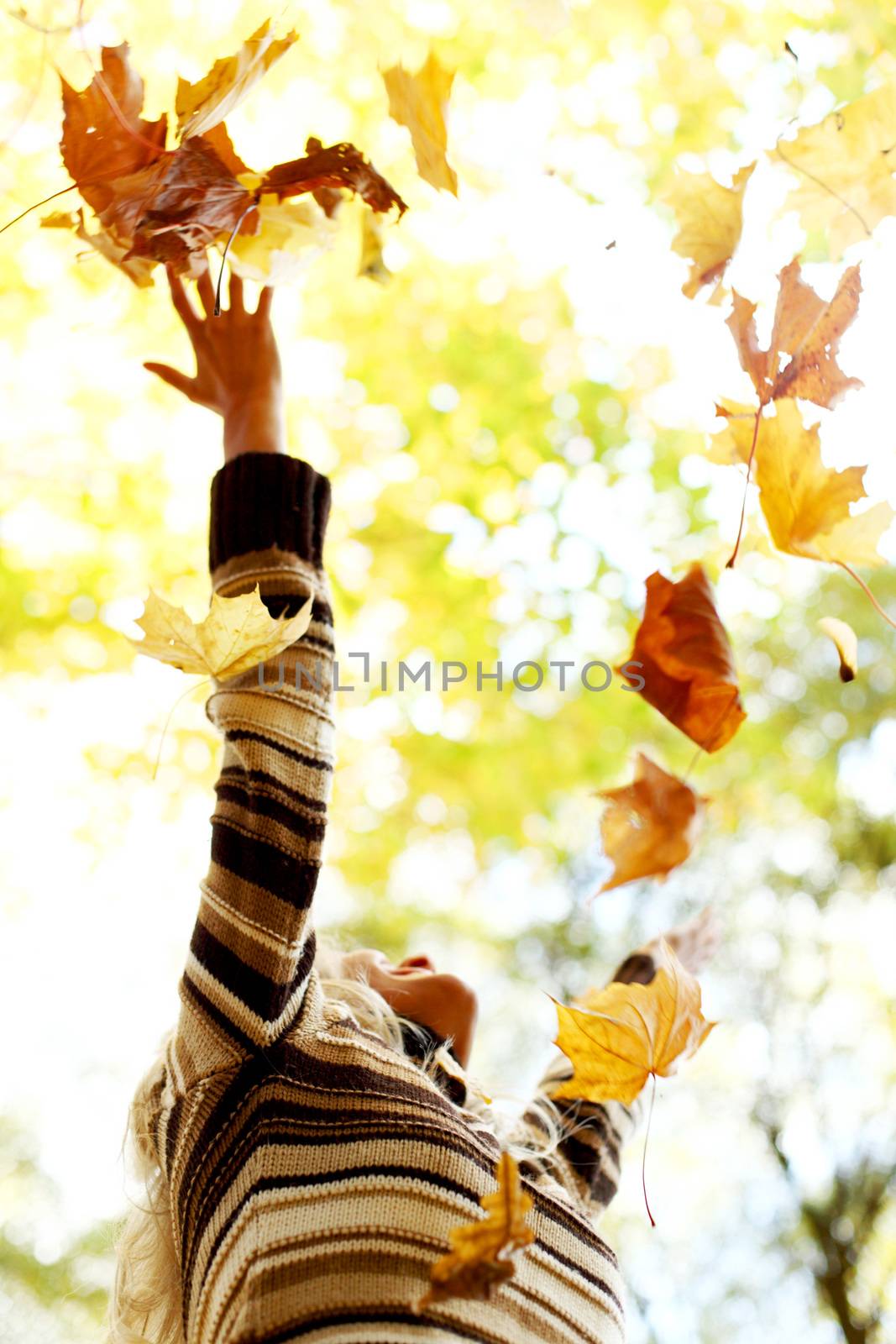 Happy young woman drop up autumn leaves