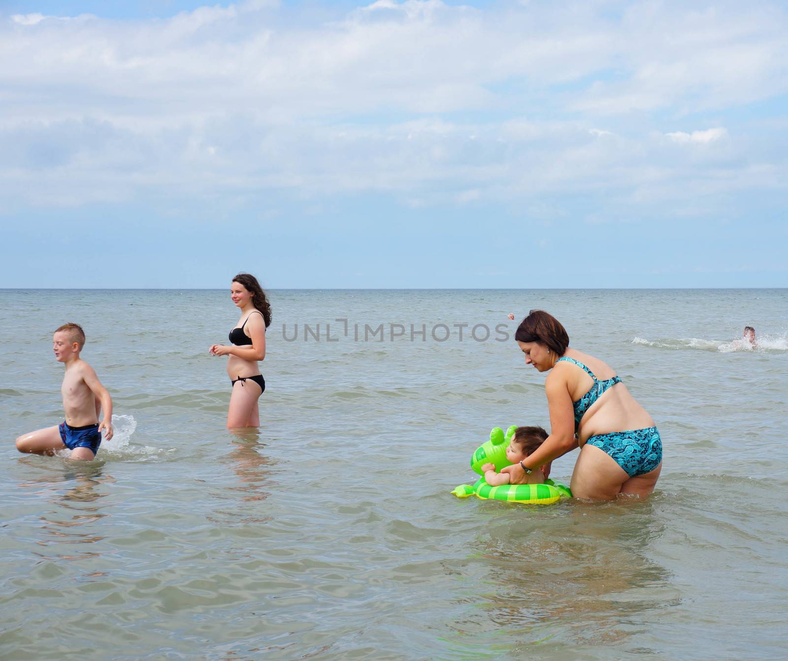 SIANOZETY, POLAND - JULY 21, 2015: Adults and children playing in the water at a beach