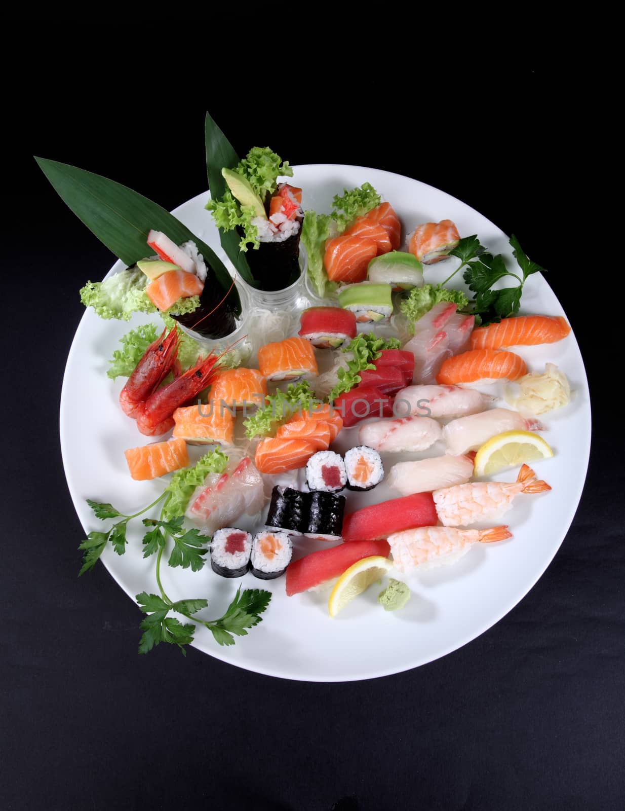 round plate of sashimi and sushi with mixed vegetables and ice