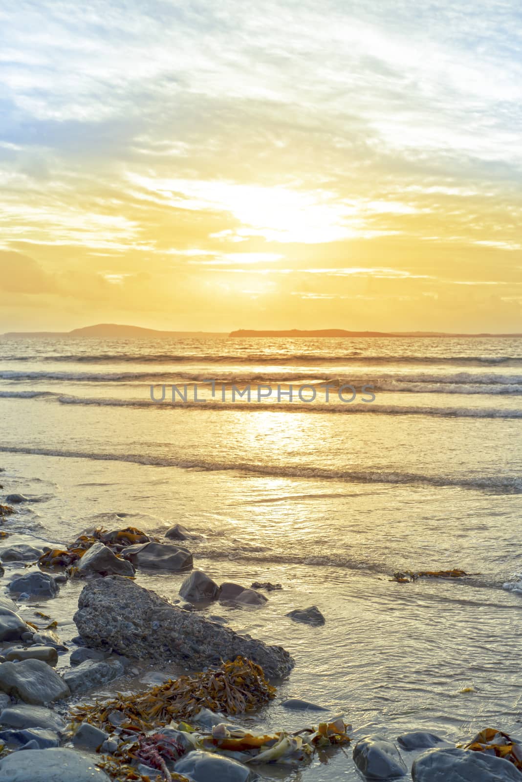 beal beach rocks and kelp sunset by morrbyte