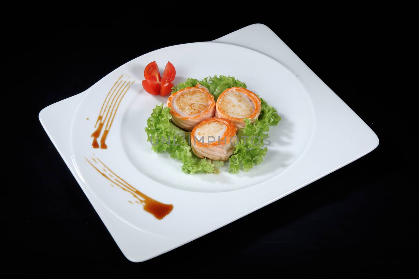 scallop dish with vegetables on a black background