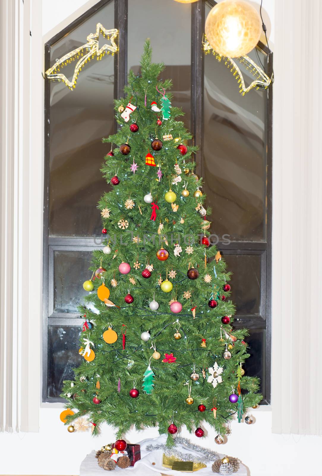 Christmas tree presents and decorations against a modern church window