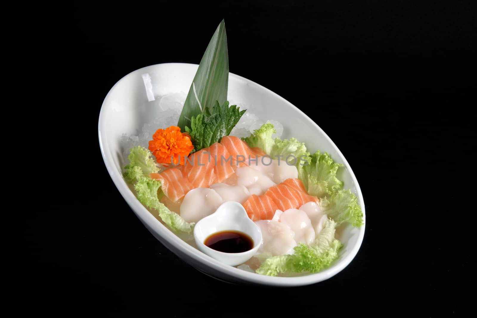 mixed sushi on white plate, black background