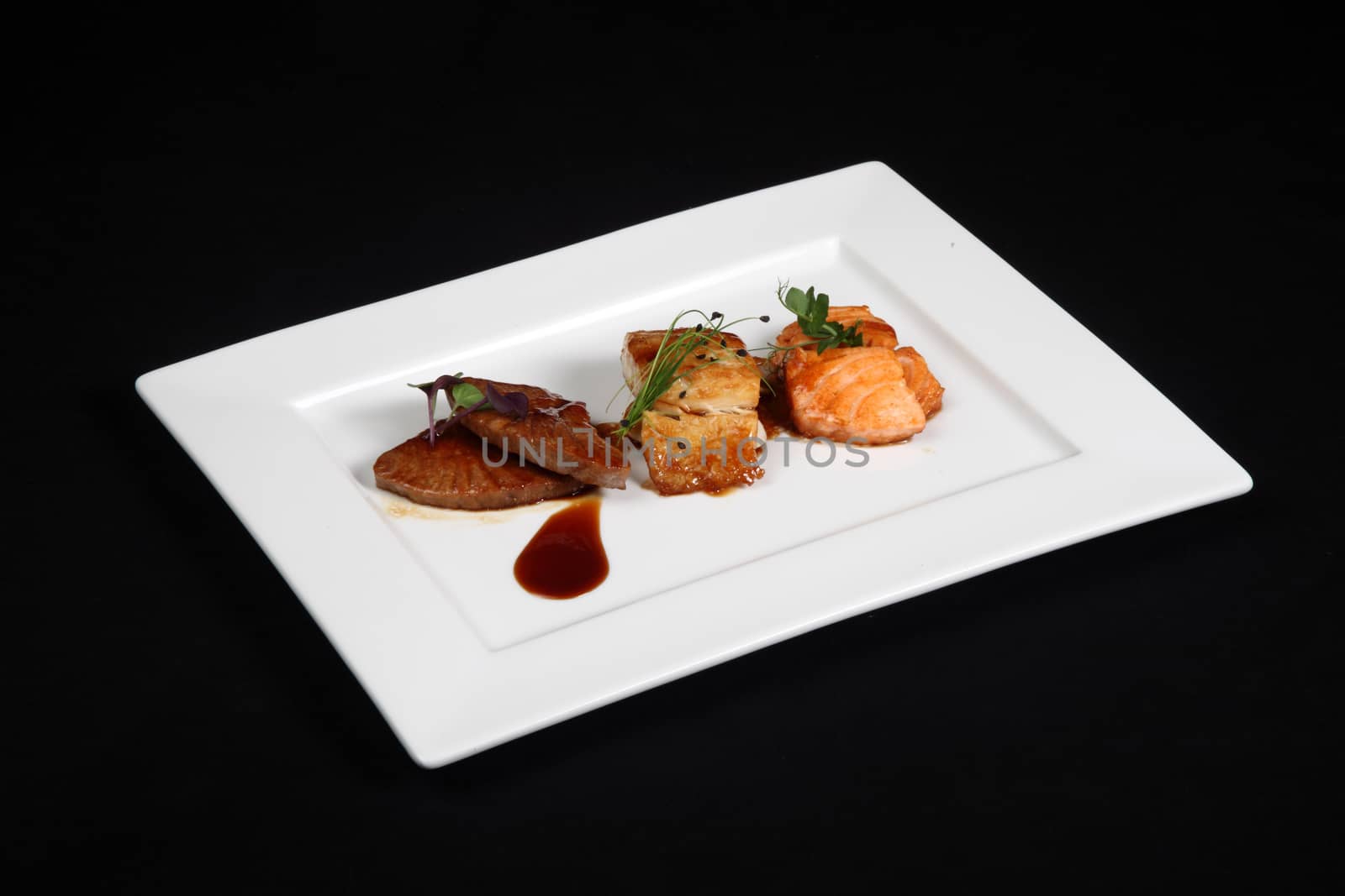 mixed fish grilled in white plate on a black background