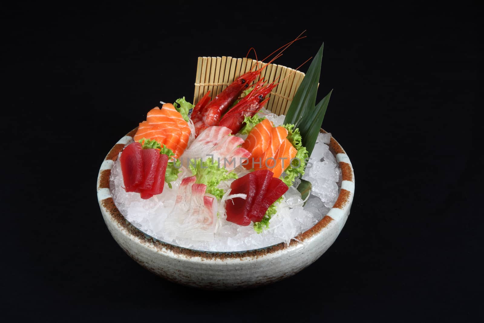 sushi mixed with ice and decoration of vegetables on a black background