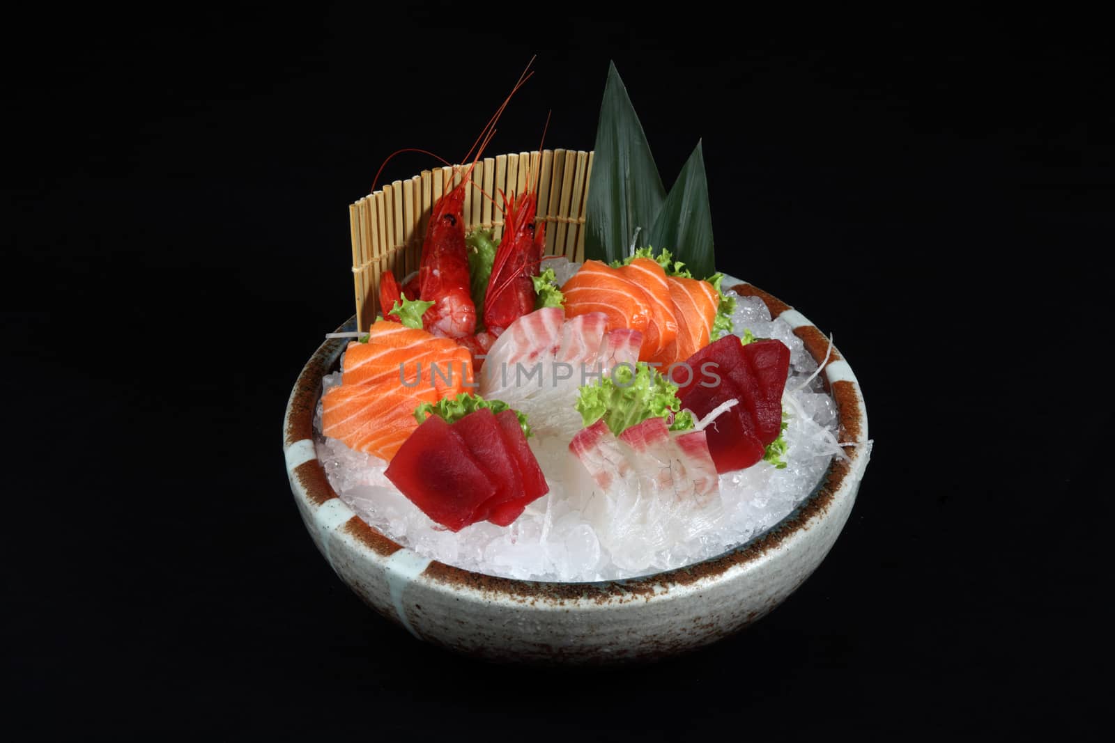 sushi mixed with ice and decoration of vegetables on a black background