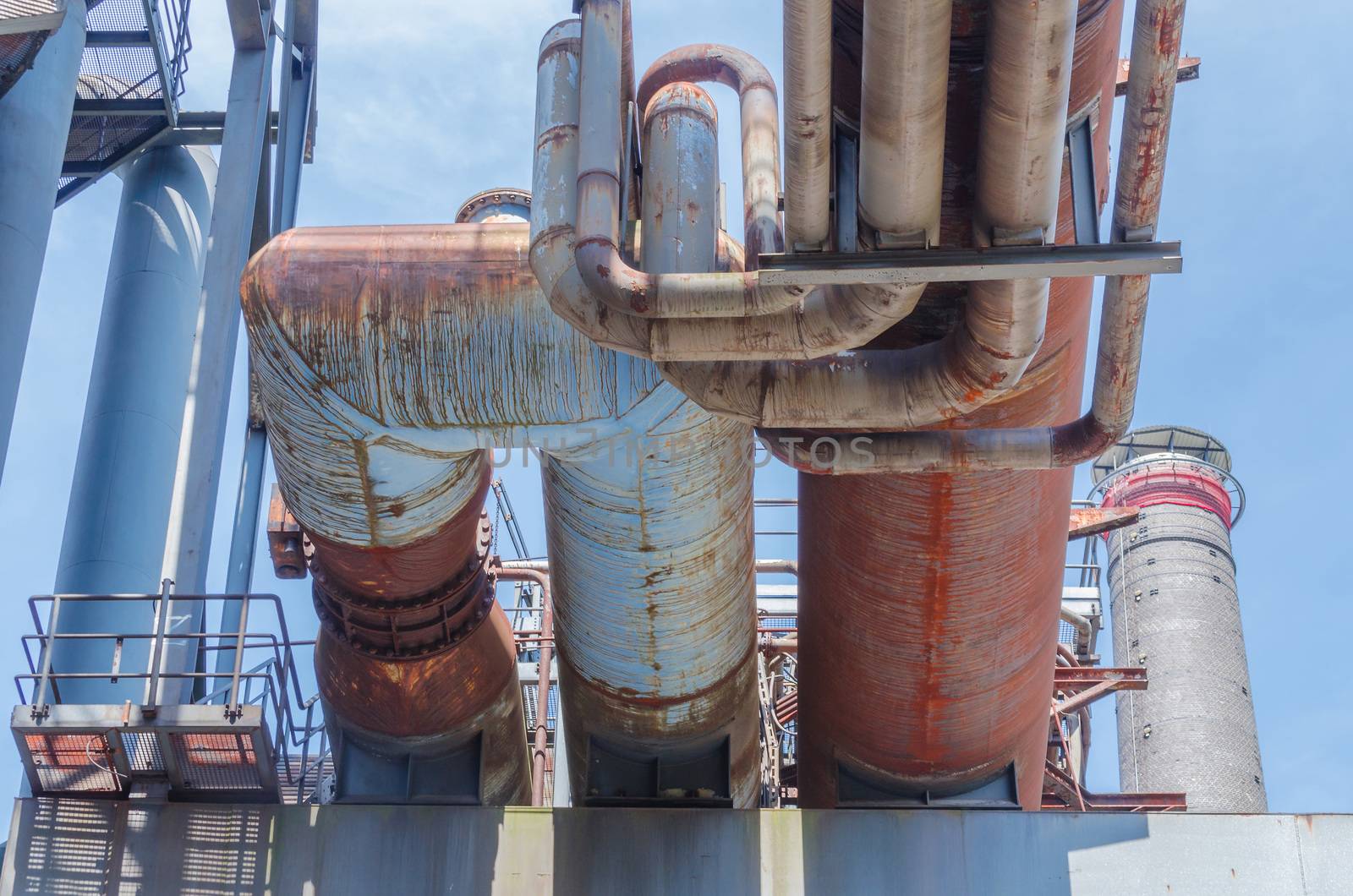 Industrial pipelines, pipelines in an old factory plant against blue sky.