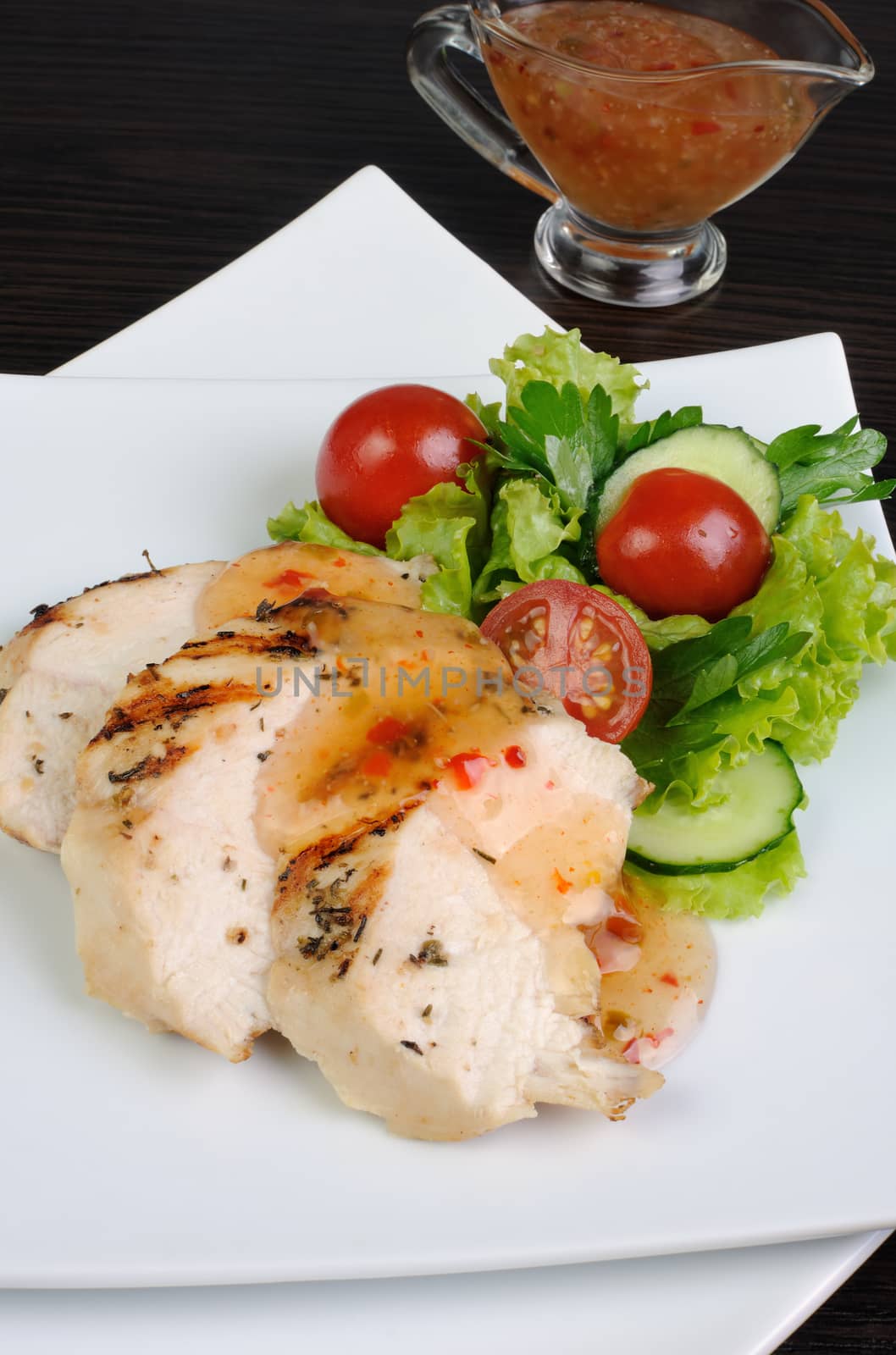 Slices of chicken breast grilled with vegetables and sauce