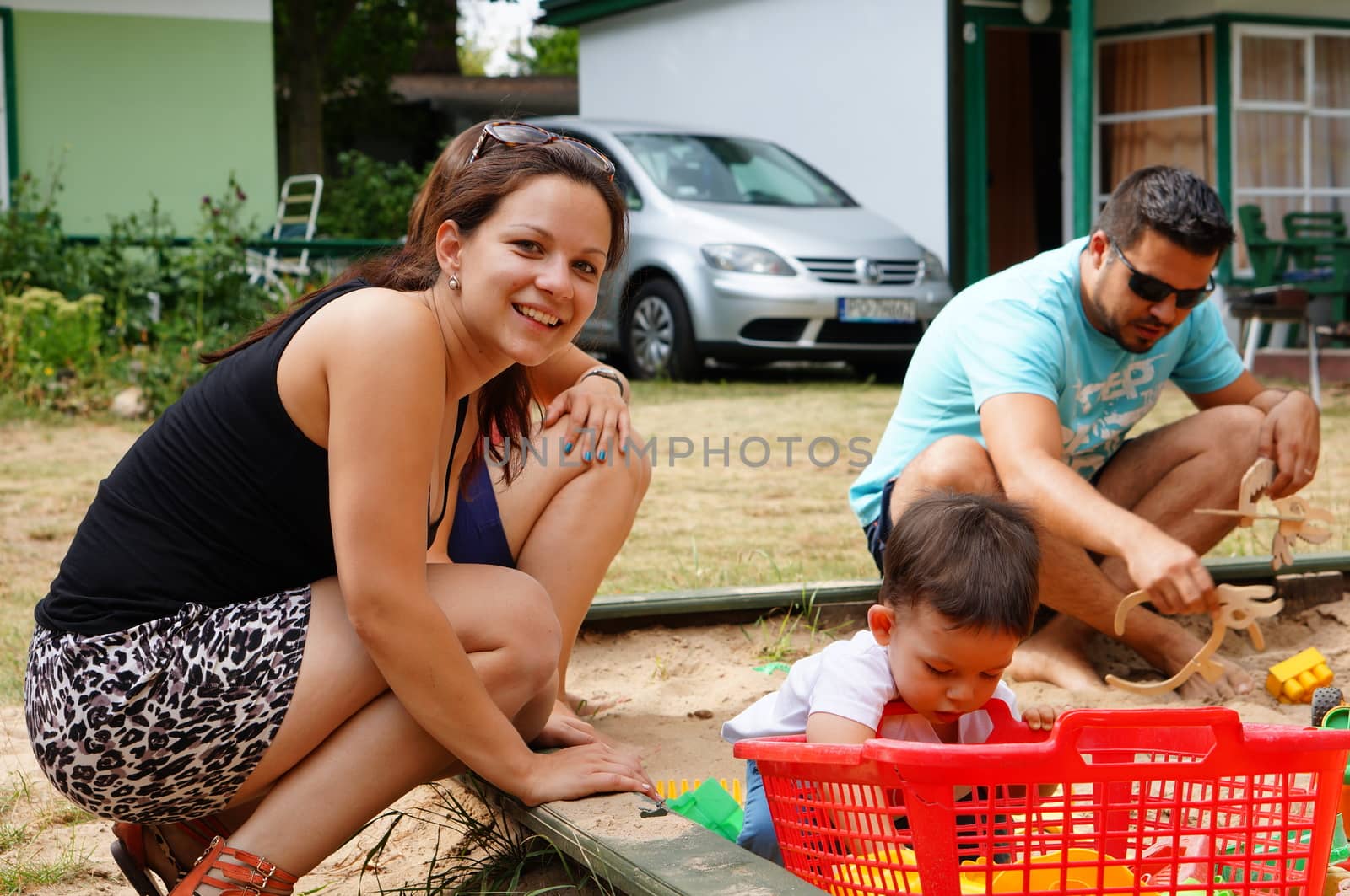 TLEN, POLAND - AUGUST 22, 2015: Woman playing with child on sand at a resort 