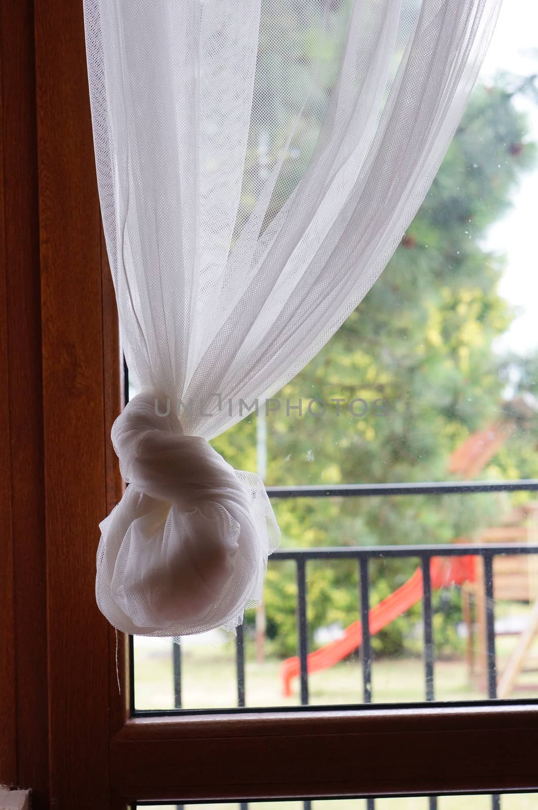 Hanging fine white curtain in front of a window