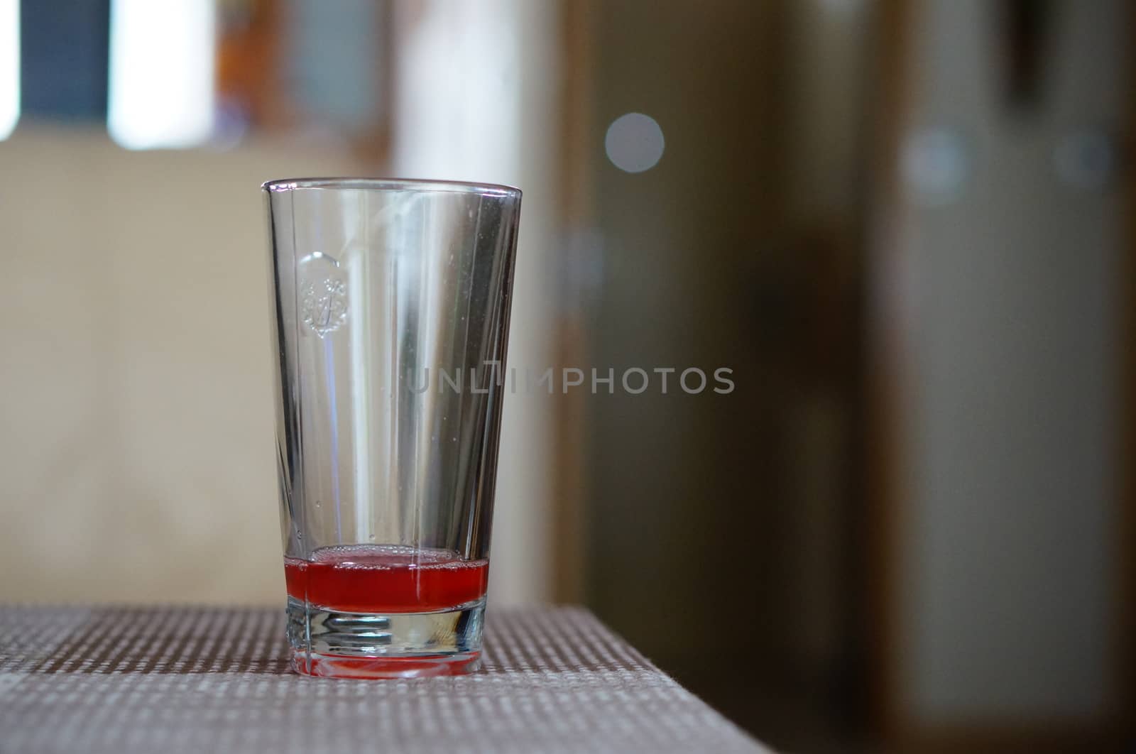 Almost empty glass with juice standing on table