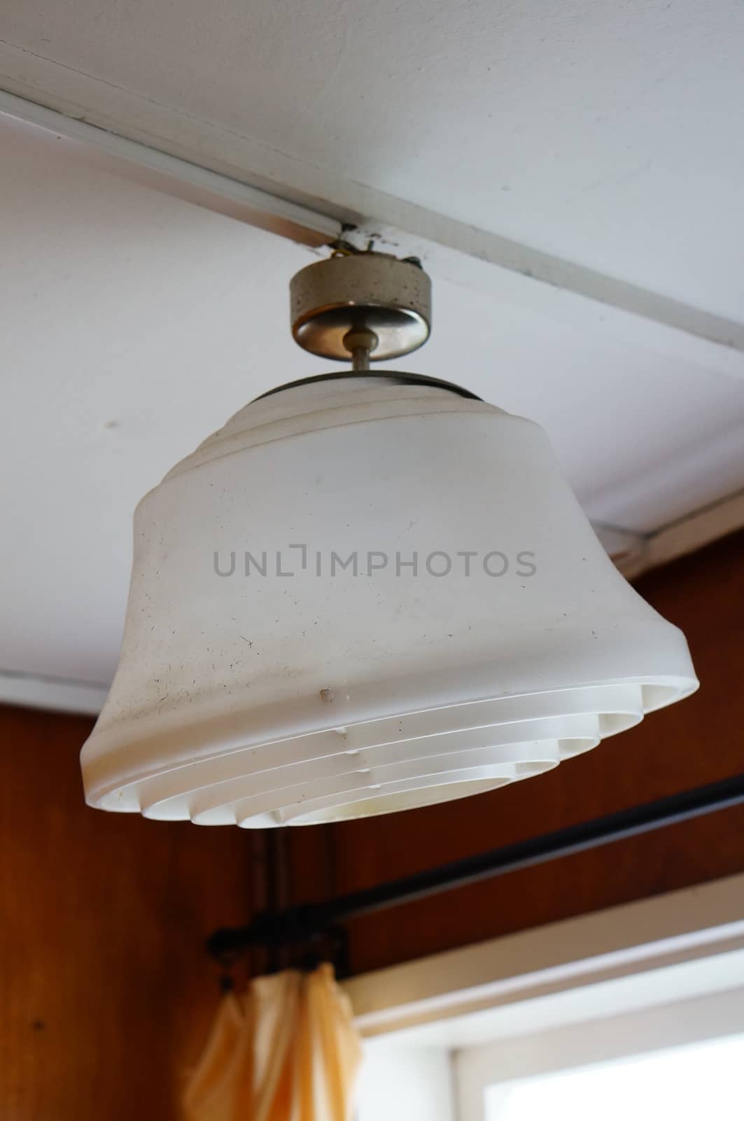 White plastic electric lamp hanging on ceiling 