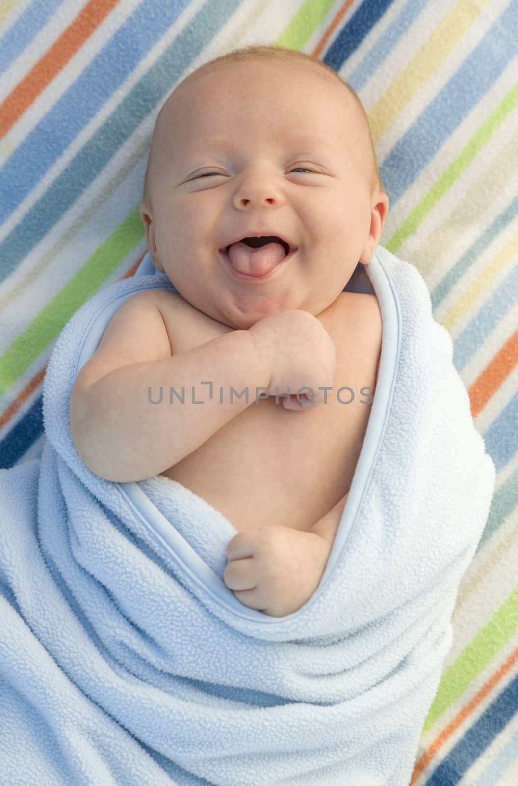 Beautiful Laughing Baby Boy Wrapped in His Blanket.