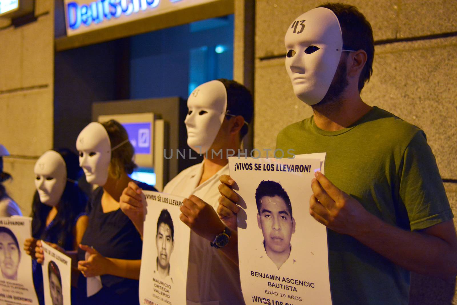SPAIN, Madrid: Protesters wearing white masks rally outside the Embassy of Mexico in Madrid, Spain on September 25, 2015, while holding up signs displaying photographs of missing Mexican students who disappeared in Iguala, Mexico on September 26 last year. Forty-six students who attended Ayotzinapa Rural Teachers' College went missing with the circumstances surrounding their disappearance still unclear