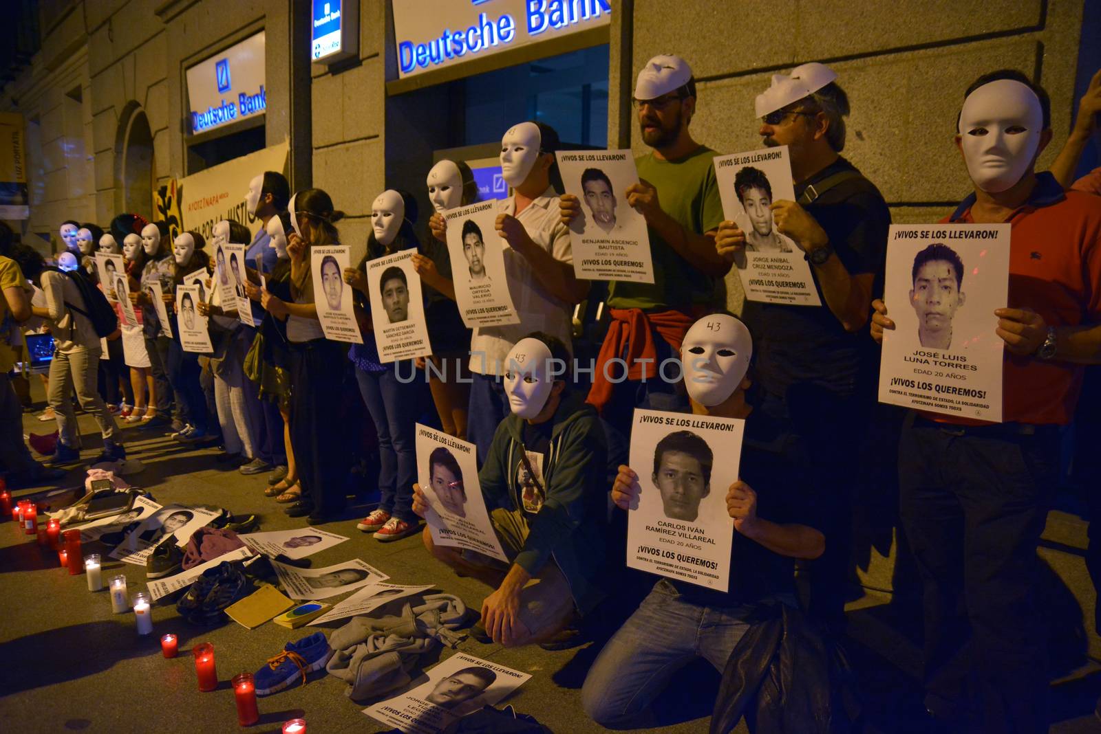 SPAIN, Madrid: Protesters wearing white masks rally outside the Embassy of Mexico in Madrid, Spain on September 25, 2015, while holding up signs displaying photographs of missing Mexican students who disappeared in Iguala, Mexico on September 26 last year. Forty-six students who attended Ayotzinapa Rural Teachers' College went missing with the circumstances surrounding their disappearance still unclear