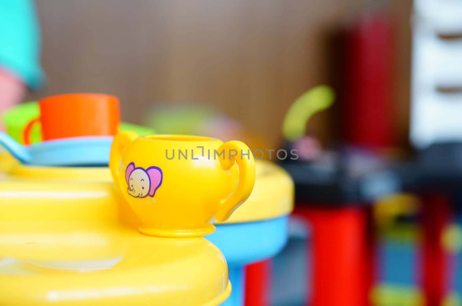 Yellow toy cup with elephant symbol on table