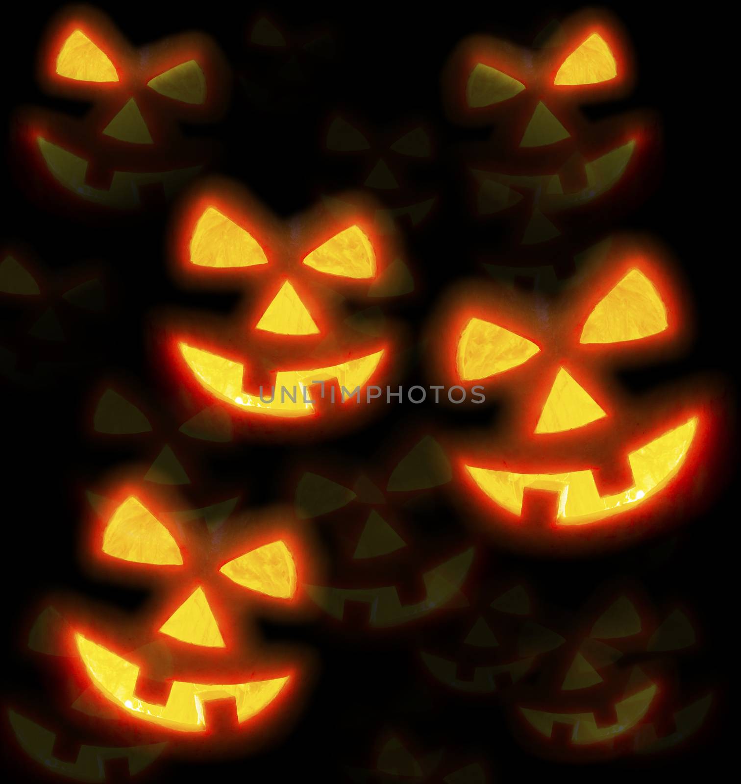 Lots of pumpkins lit brightly against a black background