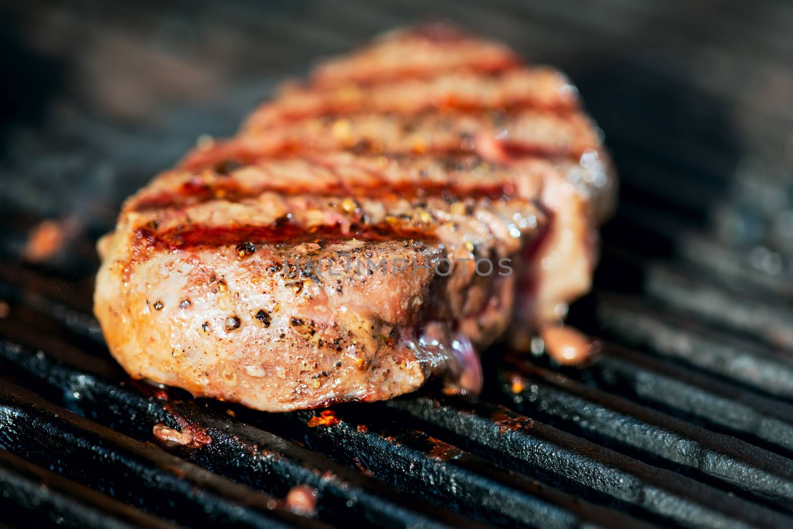 striped steak on a grill close up by Nanisimova
