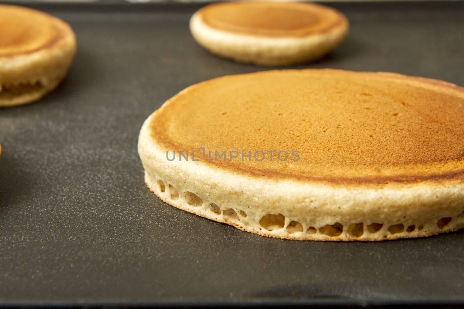 Hot cakes on a griddle cooking for breakfast