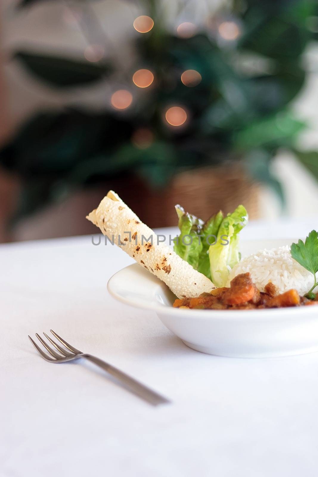 A bowl of Indian vegetable curry with rice and naan