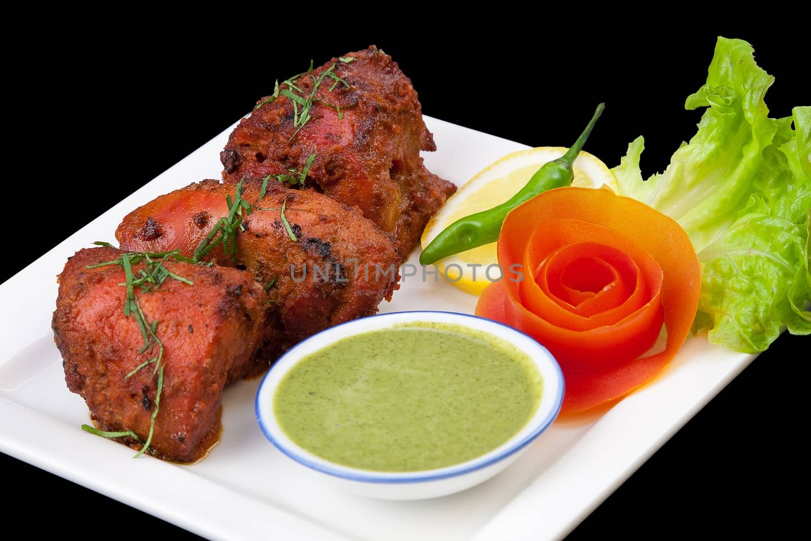 Delicious Indian tandoori chicken with salad garnishings