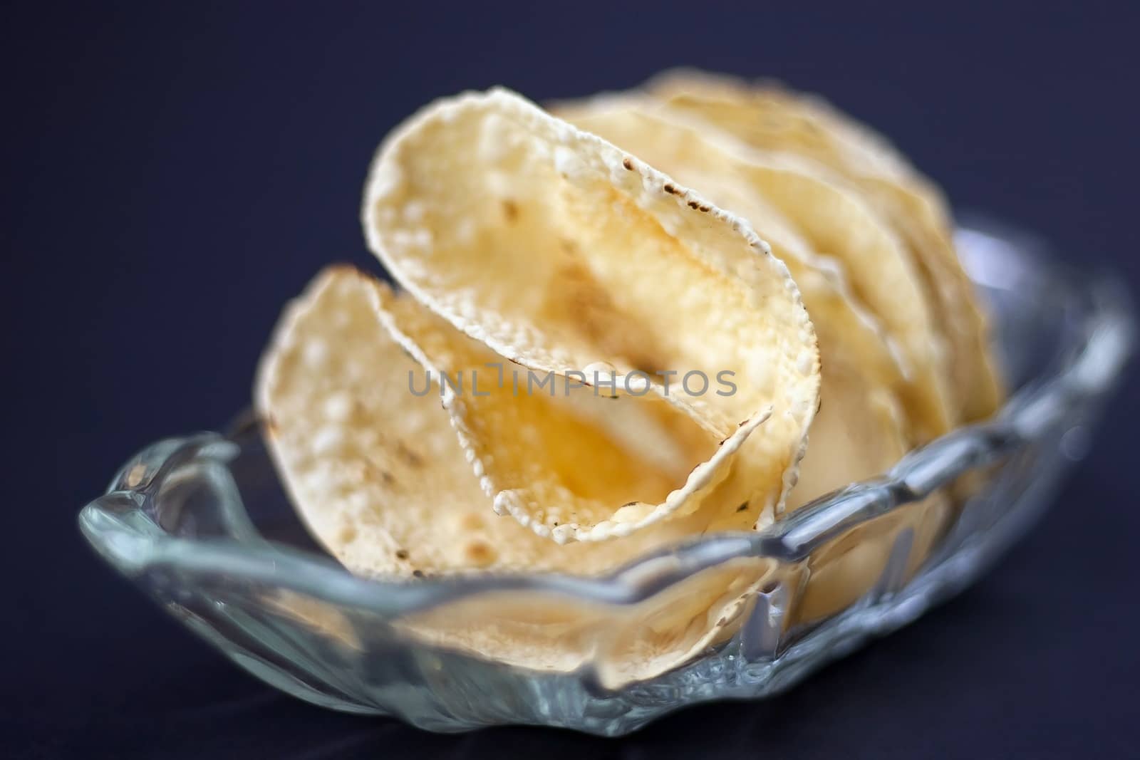 Indian Papadum crisps in a glass bowl by jaaske