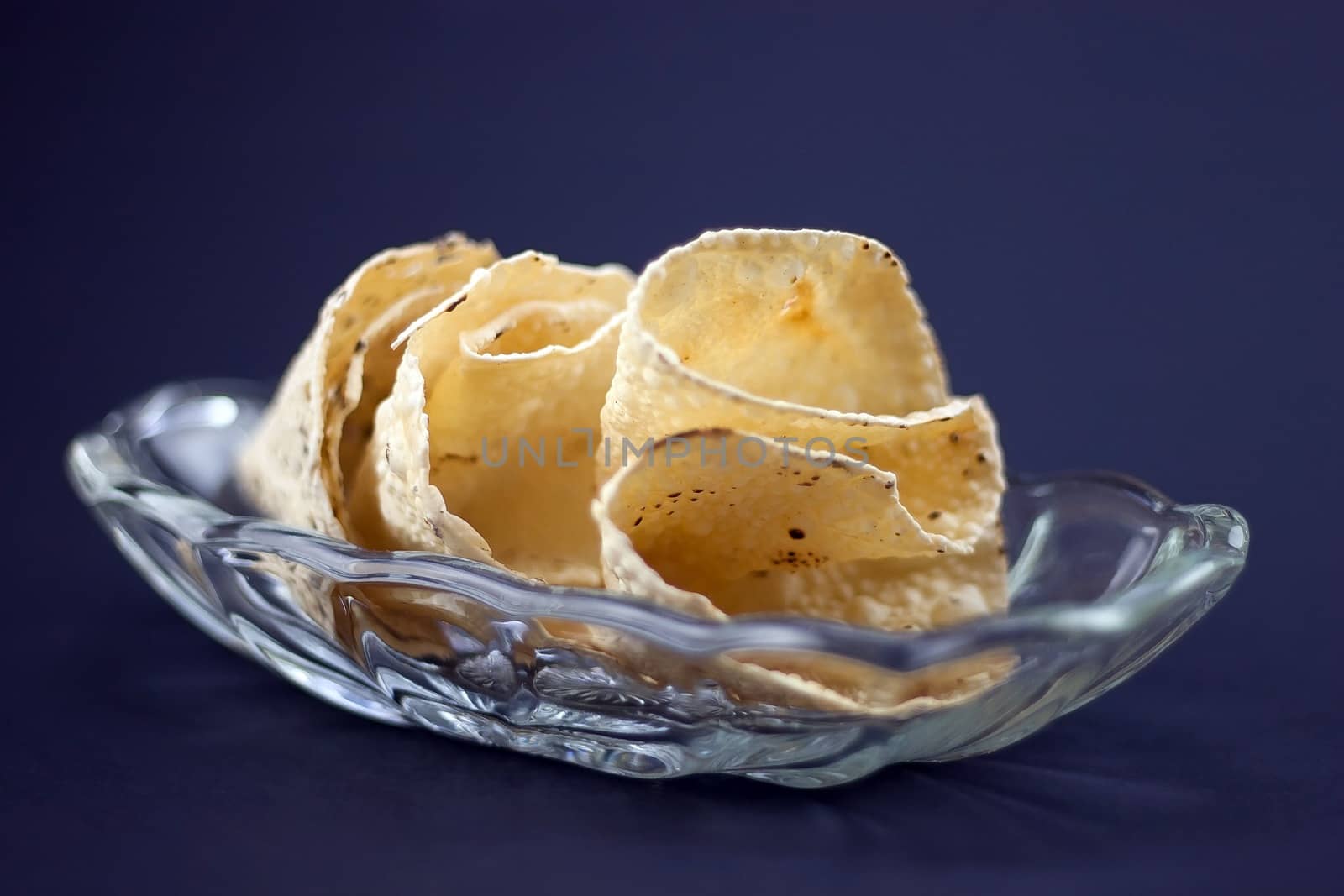 Indian Papadum crisps in a glass bowl by jaaske