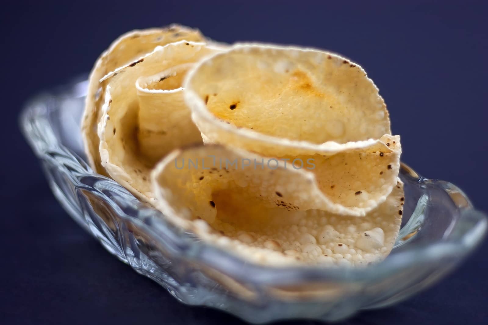 Delicious Indian Indian Papadum crisps in a glass bowl