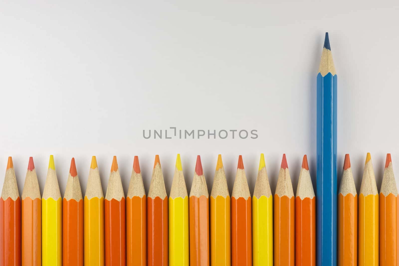 Abstract composition of a set wooden colour pencils against a white background
