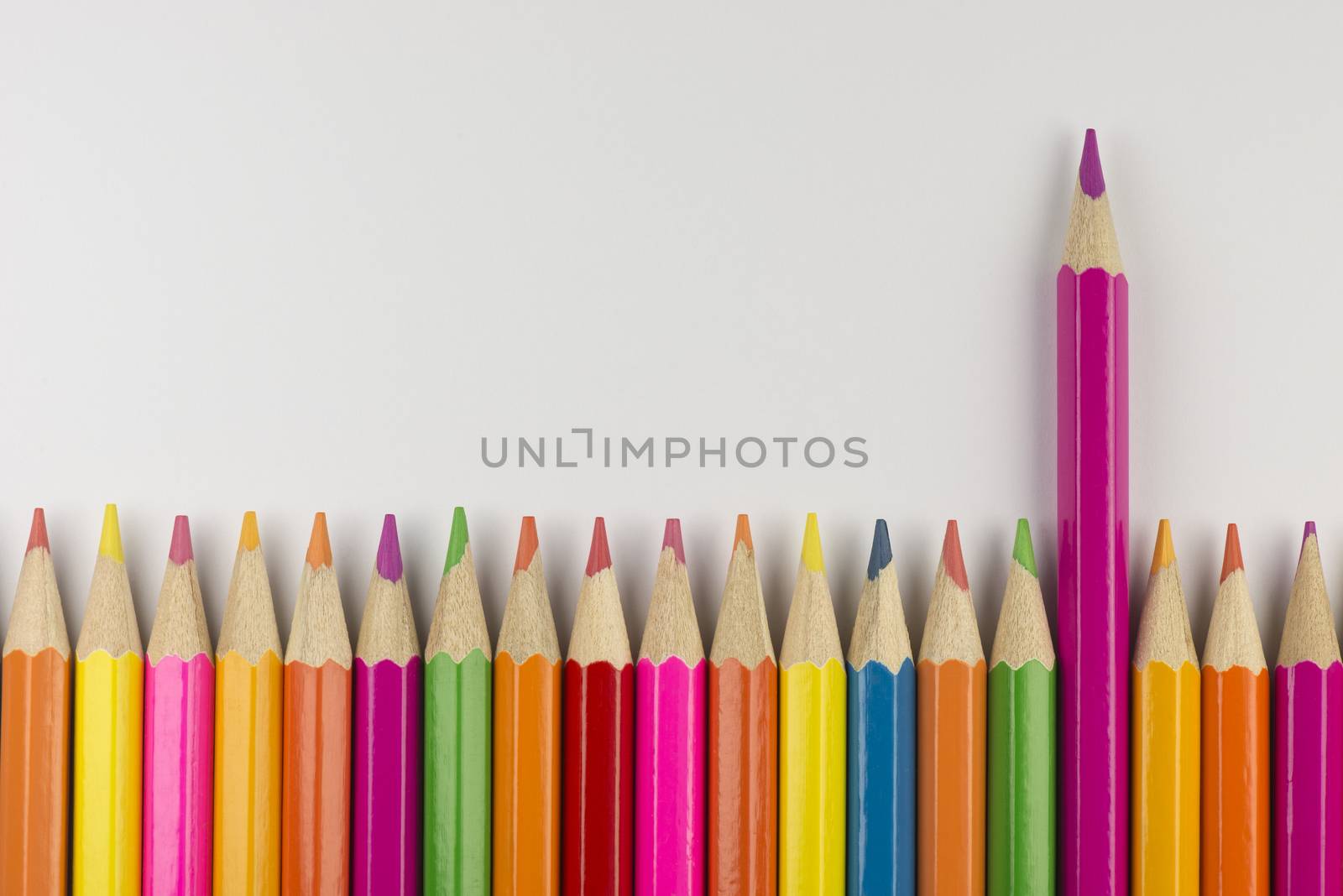 Abstract composition of a set wooden colour pencils against a white background
